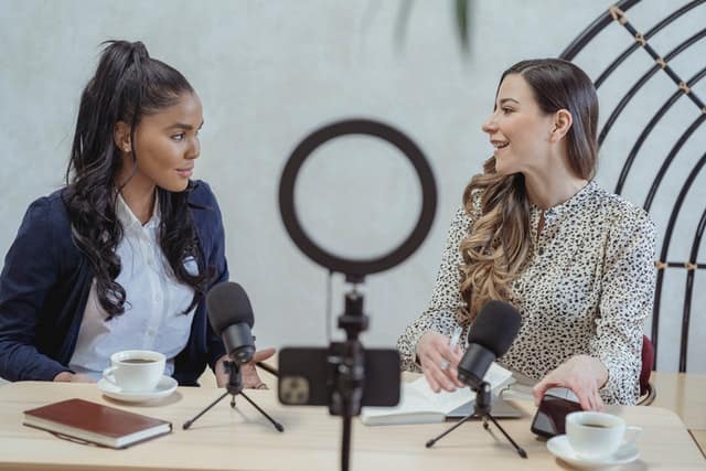 An image of two girls doing podcast for digital product ideas